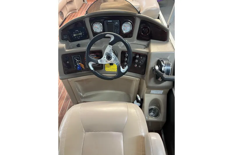 Slide: The Image of Steering console of 2013 Crest Classic 230 boat with beige seating and control panel. - 6