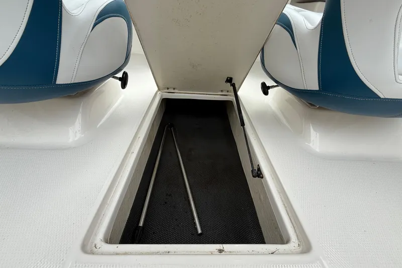 Slide: The Image of 2016 Chaparral 19 H2O Sport boat storage compartment with blue and white seats. - 15