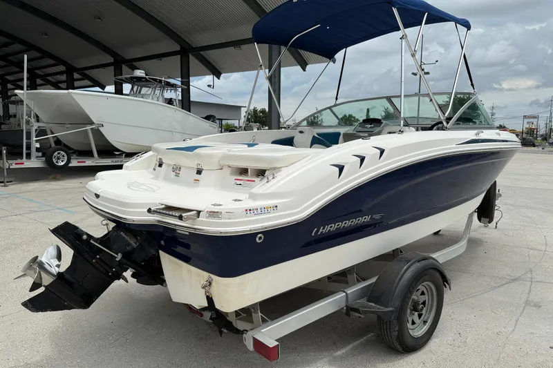 Slide: The Image of 2016 Chaparral 19 H2O Sport boat with blue canopy on trailer. - 6