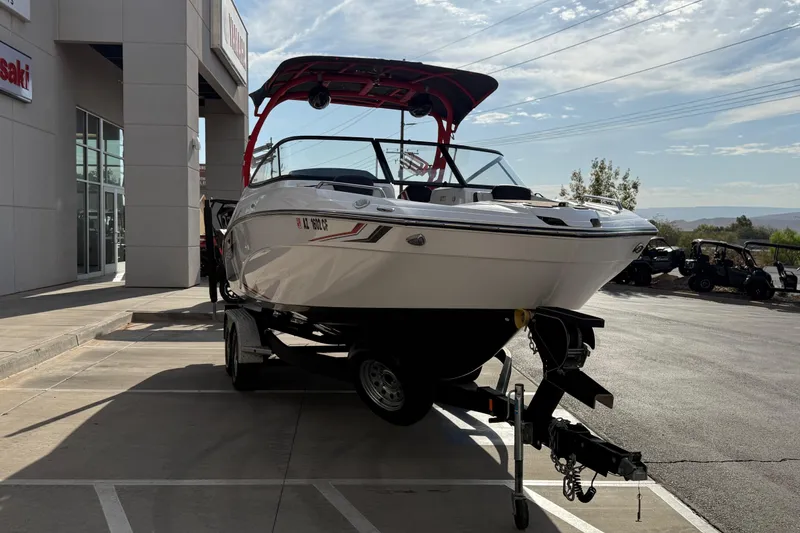 Slide: The Image of 2019 Yamaha Boats 242X E-Series on trailer outside dealership, sunny day. - 17