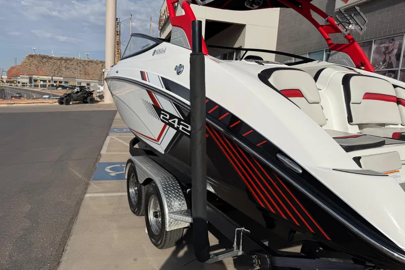 Slide: The Image of 2019 Yamaha Boats 242X E-Series on trailer, featuring sleek design and red accents. - 20