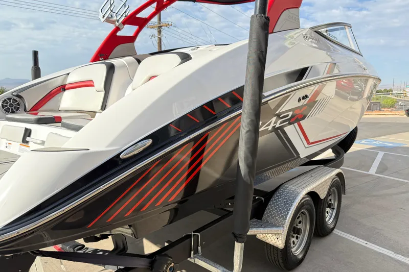 Slide: The Image of 2019 Yamaha Boats 242X E-Series on trailer, featuring sleek design and red accents. - 25