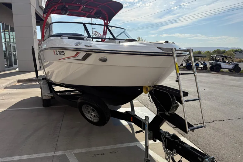 Slide: The Image of 2019 Yamaha Boats 242X E-Series on trailer, parked outdoors near dealership. - 28