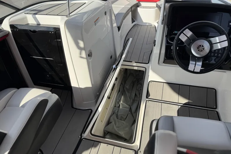 Slide: The Image of 2019 Yamaha Boats 242X E-Series interior with steering wheel and storage compartment. - 57
