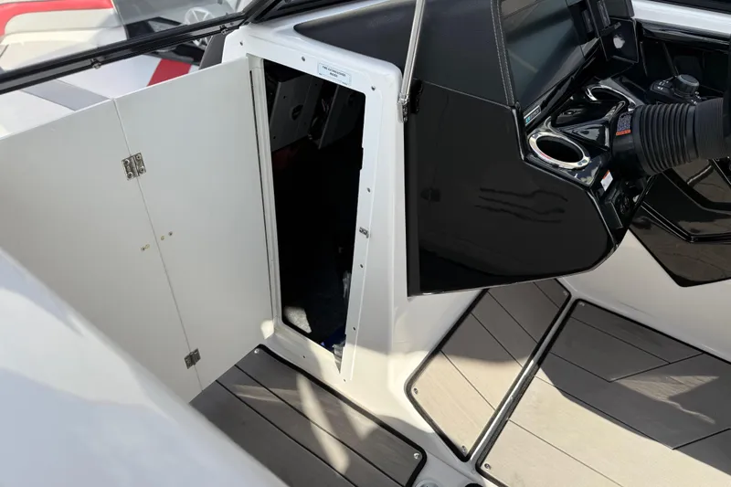 Slide: The Image of 2019 Yamaha Boats 242X E-Series interior with open storage compartment and control panel. - 66