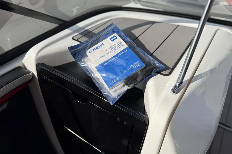 Slide: The Image of 2019 Yamaha Boats 242X E-Series manual on boat console. - 72