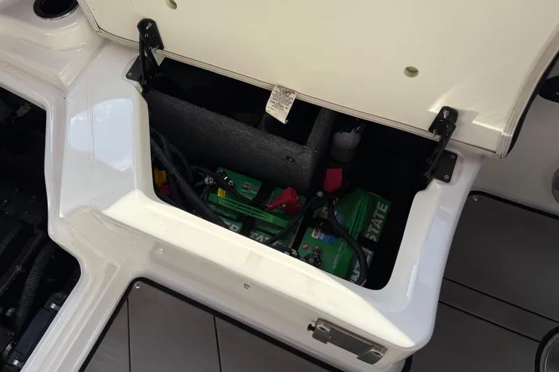 Slide: The Image of 2019 Yamaha Boats 242X E-Series battery compartment with visible wiring and components. - 75