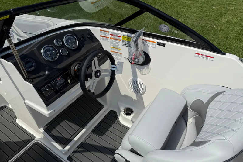 Slide: The Image of 2025 Bayliner VR4 Bowrider I/O cockpit with steering wheel, gauges, and cushioned seating. - 10