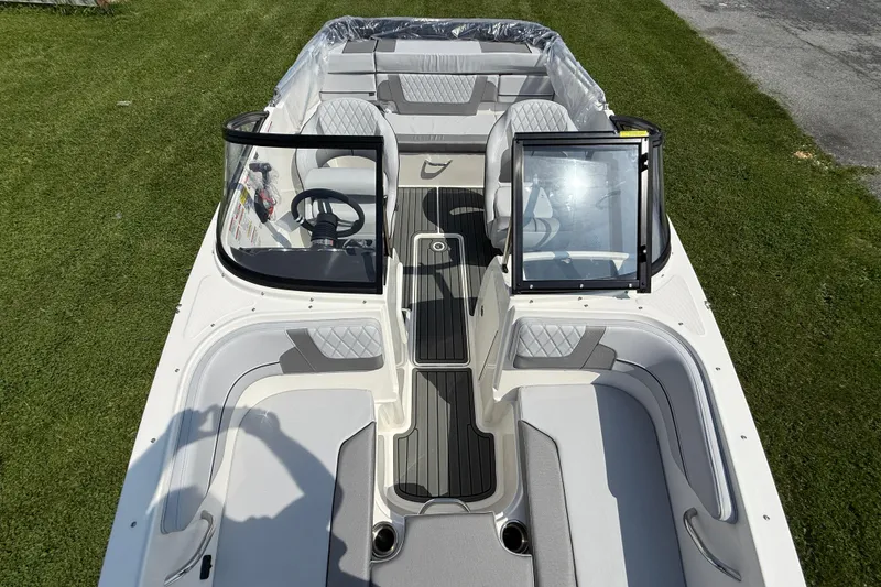Slide: The Image of 2025 Bayliner VR4 Bowrider I/O boat interior with seating and steering wheel, on grass. - 15