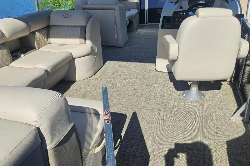 Slide: The Image of 2018 Harris Cruiser 200 pontoon boat interior with beige seating and steering console. - 4