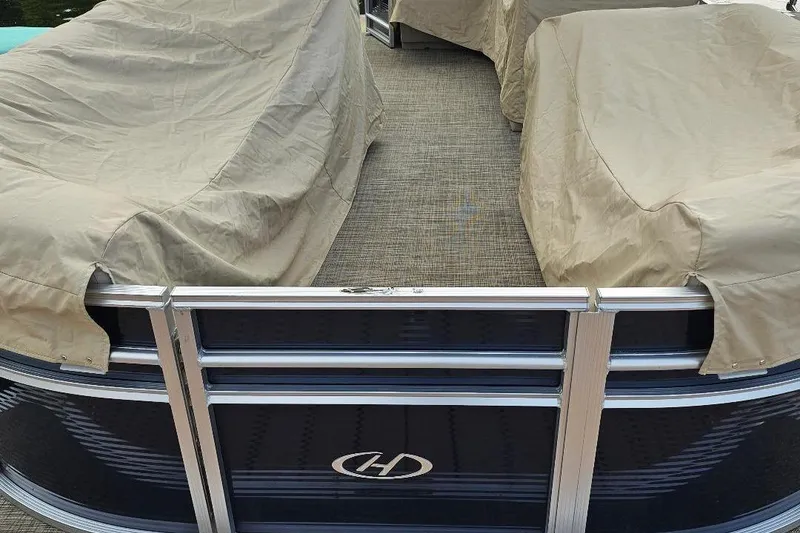 Slide: The Image of 2018 Harris Cruiser 200 pontoon boat with protective covers, viewed from the rear. - 5