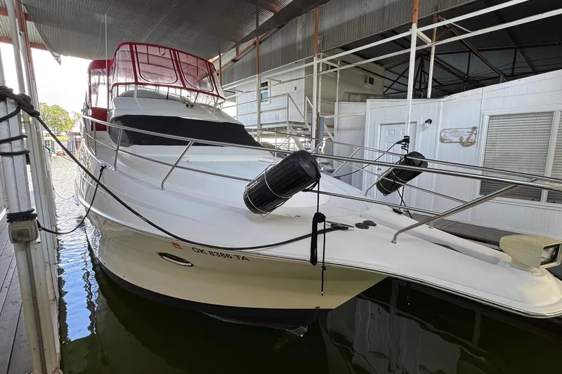 Slide: The Image of 2003 Silverton 410 Sport Bridge yacht docked in a marina, featuring sleek design and red canopy. - 1