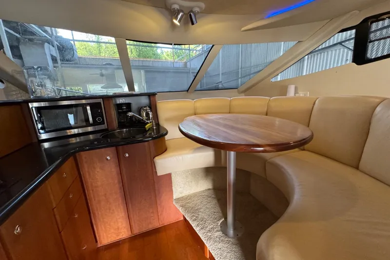 Slide: The Image of 2003 Silverton 410 Sport Bridge interior with kitchenette and curved seating area. - 15
