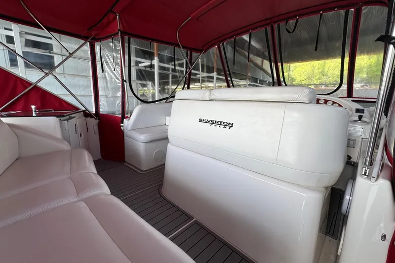 Slide: The Image of Interior of 2003 Silverton 410 Sport Bridge yacht with white seating and red canopy. - 20