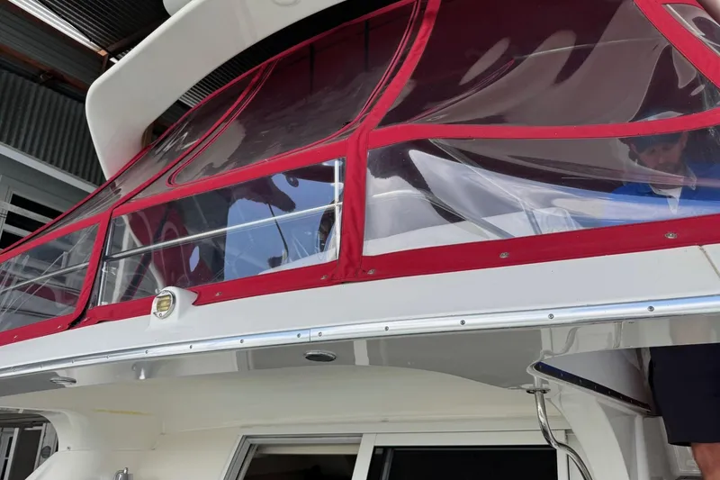 Slide: The Image of 2003 Silverton 410 Sport Bridge with red canopy and sleek design. - 24