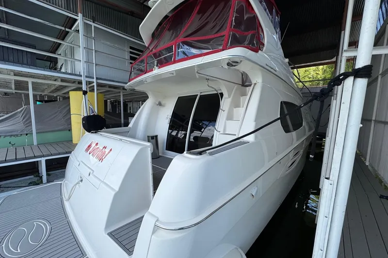 Slide: The Image of 2003 Silverton 410 Sport Bridge yacht docked in a covered marina. - 28