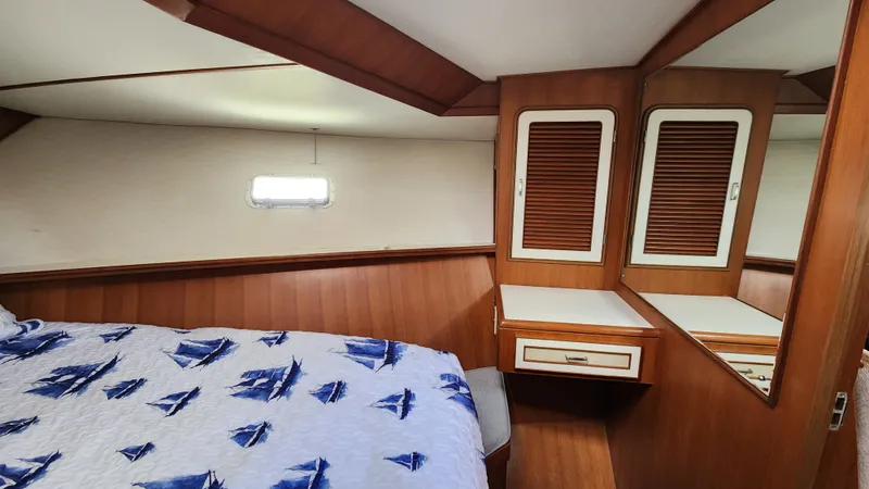 Slide: The Image of 1987 Hi-Star 48 Sundeck cabin with nautical-themed bedding and wooden cabinetry. - 11