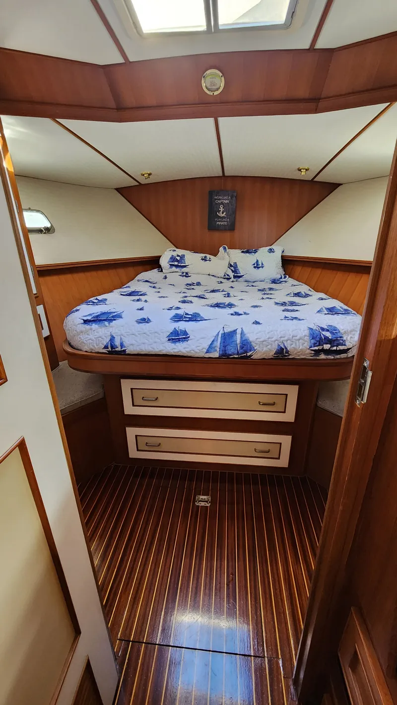Slide: The Image of 1987 Hi-Star 48 Sundeck cabin with nautical-themed bedding and wooden interior. - 12