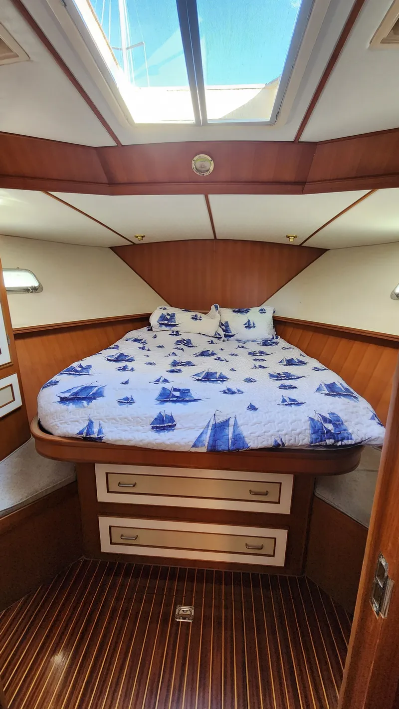 Slide: The Image of 1987 Hi-Star 48 Sundeck cabin with nautical-themed bedding and skylight. - 13