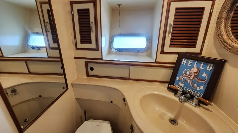 Slide: The Image of 1987 Hi-Star 48 Sundeck bathroom with sink, mirror, and nautical decor. - 15