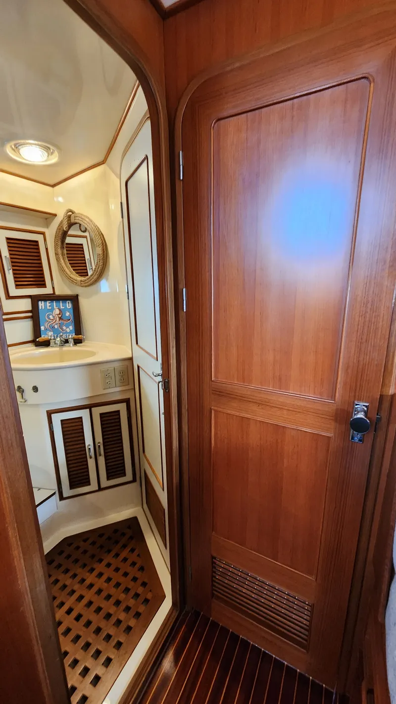 Slide: The Image of 1987 Hi-Star 48 Sundeck yacht bathroom with wooden door and nautical decor. - 19