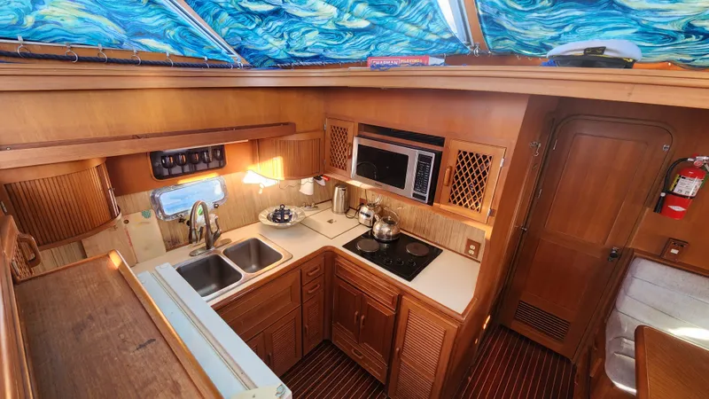 Slide: The Image of 1987 Hi-Star 48 Sundeck yacht kitchen with wood cabinetry and modern appliances. - 22