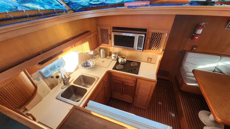 Slide: The Image of 1987 Hi-Star 48 Sundeck yacht kitchen with wooden cabinetry, dual sink, and modern appliances. - 25