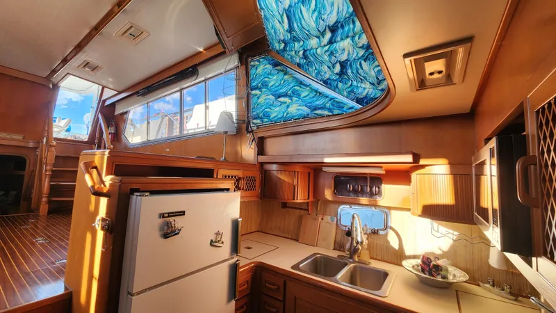 Slide: The Image of Interior of 1987 Hi-Star 48 Sundeck yacht kitchen with wood finish and blue skylight. - 27