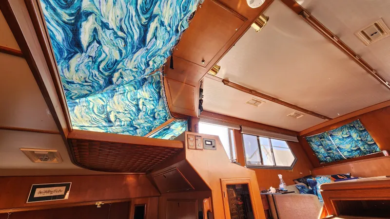 Slide: The Image of Interior of 1987 Hi-Star 48 Sundeck with vibrant blue patterned curtains. - 28