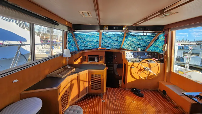 Slide: The Image of 1987 Hi-Star 48 Sundeck interior with wooden flooring and nautical-themed curtains. - 29