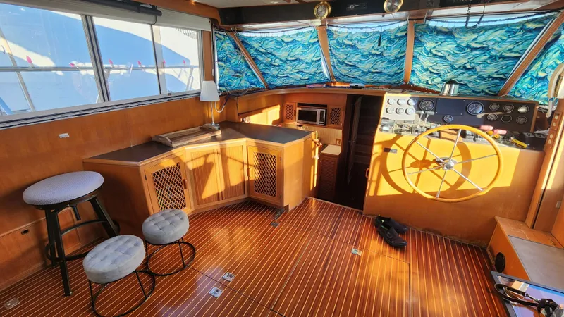 Slide: The Image of 1987 Hi-Star 48 Sundeck interior with wooden flooring, helm, and seating area. - 31