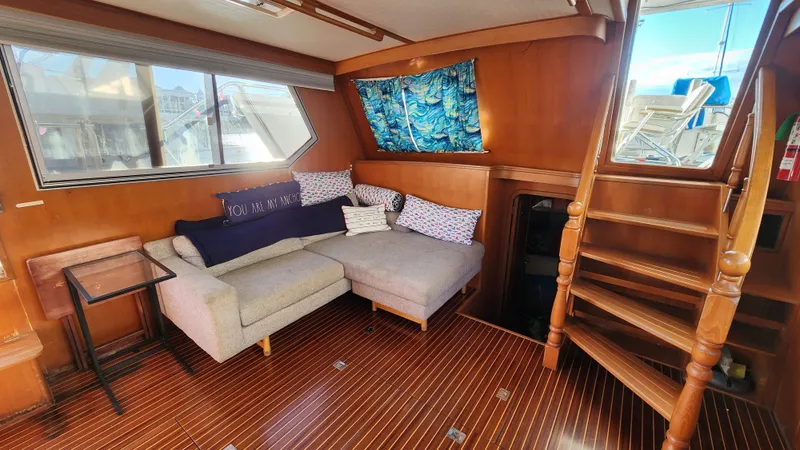 Slide: The Image of 1987 Hi-Star 48 Sundeck interior with cozy seating, wooden flooring, and nautical decor. - 36