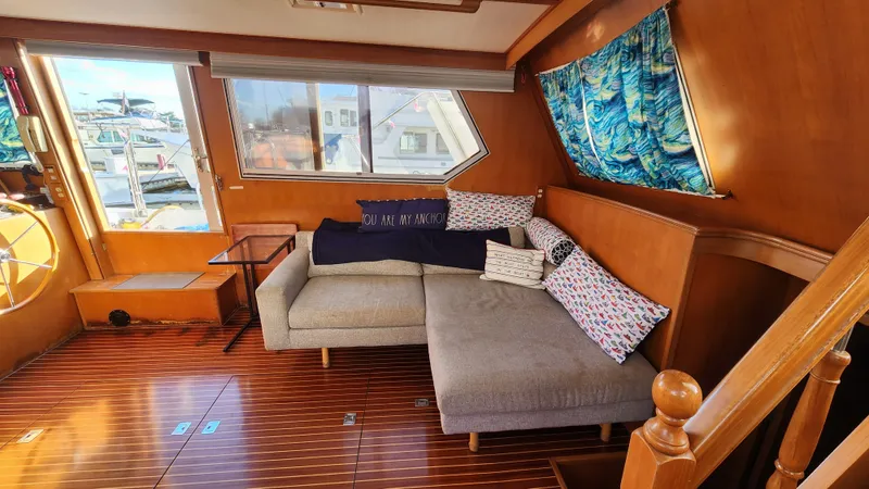 Slide: The Image of 1987 Hi-Star 48 Sundeck interior with cozy seating, nautical decor, and wooden flooring. - 38