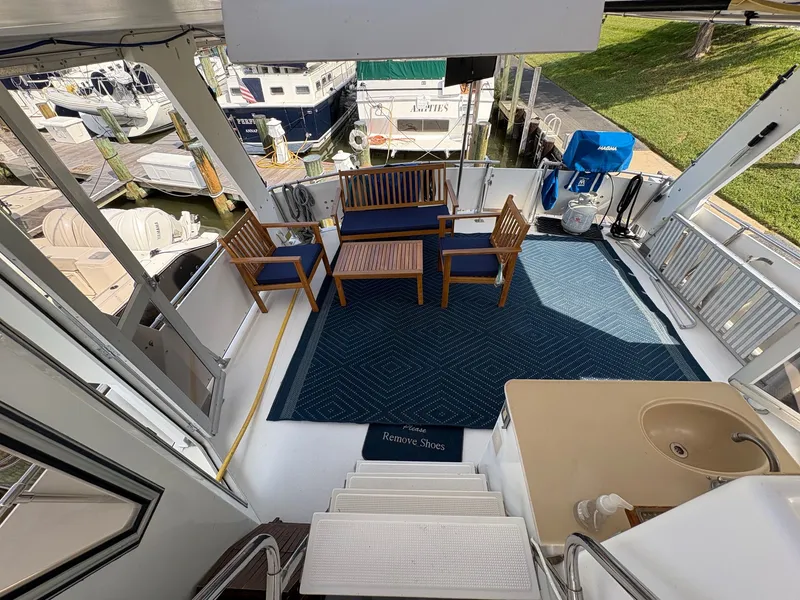 Slide: The Image of 1987 Hi-Star 48 Sundeck with outdoor seating, blue rug, and marina view. - 4