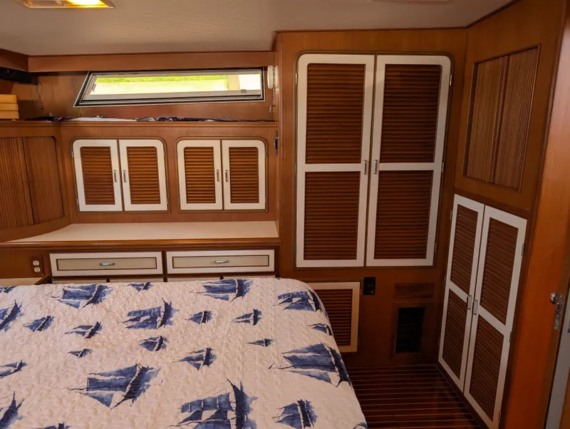 Slide: The Image of 1987 Hi-Star 48 Sundeck cabin with nautical-themed bedding and wooden cabinetry. - 40
