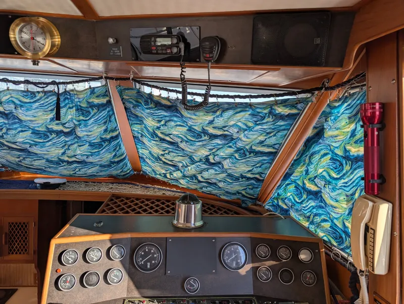 Slide: The Image of Interior of 1987 Hi-Star 48 Sundeck with nautical instruments and vibrant blue curtains. - 48