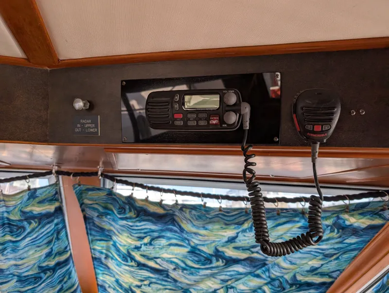 Slide: The Image of 1987 Hi-Star 48 Sundeck interior with radio equipment and vibrant blue curtains. - 49