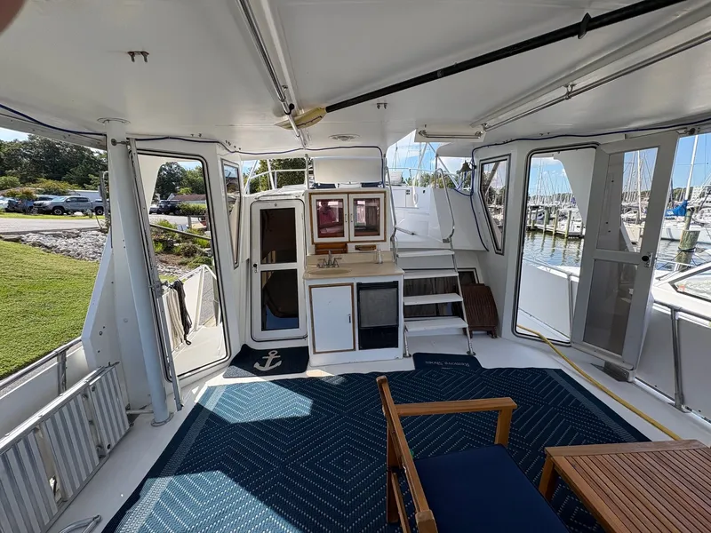Slide: The Image of 1987 Hi-Star 48 Sundeck interior with seating, table, and marina view. - 5