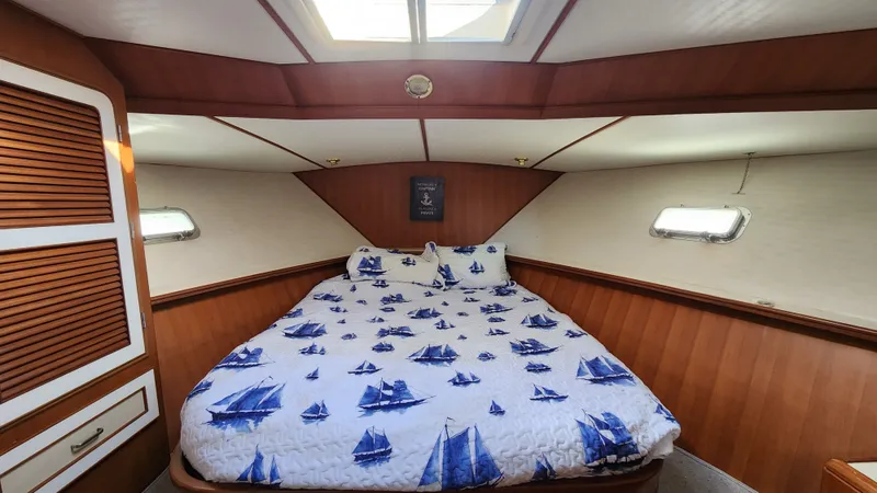 Slide: The Image of 1987 Hi-Star 48 Sundeck bedroom with nautical-themed bedding and wooden interior. - 6