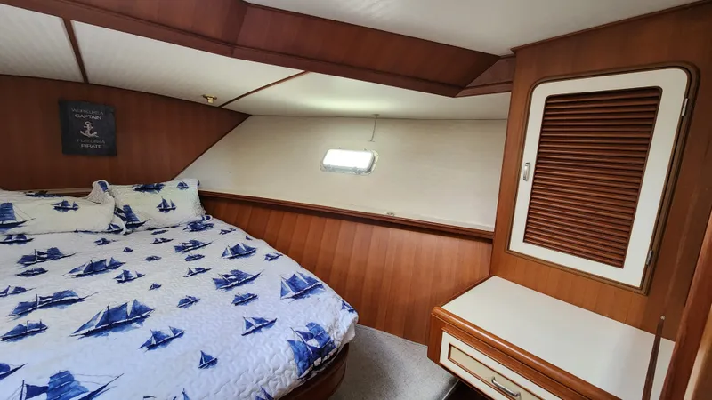Slide: The Image of 1987 Hi-Star 48 Sundeck cabin with nautical-themed bedding and wooden interior. - 8