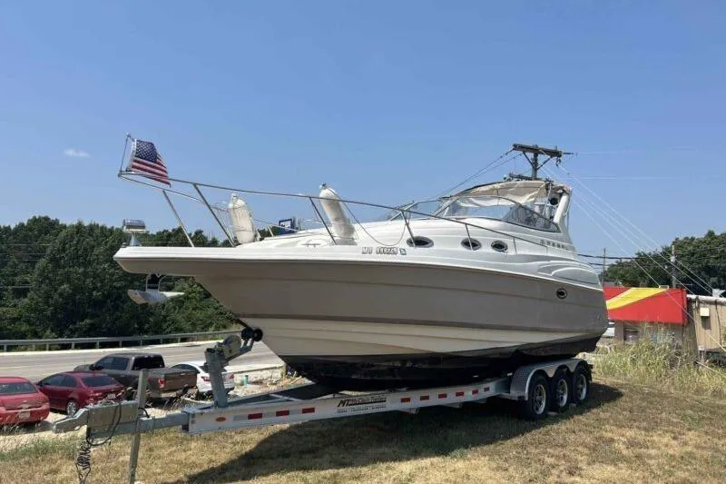 The Image of 2003 Regal Commodore 2860 boat on trailer, parked outdoors with American flag. - 1