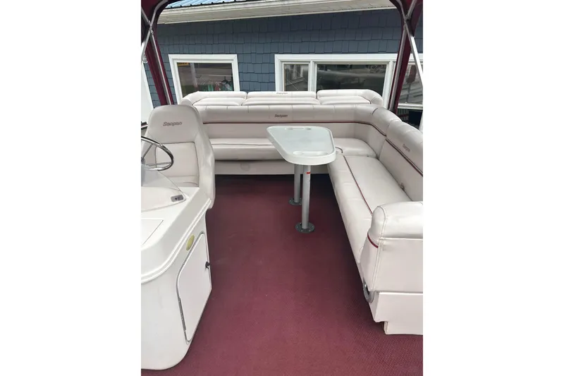 Slide: The Image of 1999 Sanpan 2500 LE boat interior with white seating and table. - 3