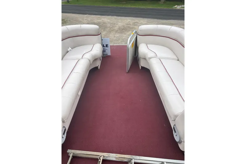 Slide: The Image of 1999 Sanpan 2500 LE pontoon boat interior with white seating and red carpet. - 4