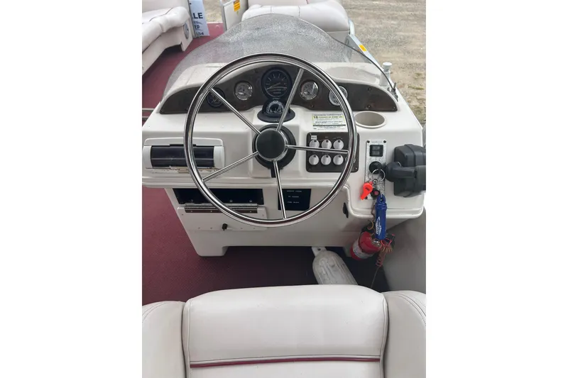 Slide: The Image of 1999 Sanpan 2500 LE boat dashboard with steering wheel and control panel. - 5