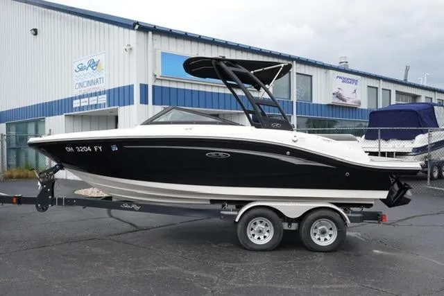 Slide: The Image of 2020 Sea Ray SPX 190 boat on trailer outside dealership, black and white design. - 1