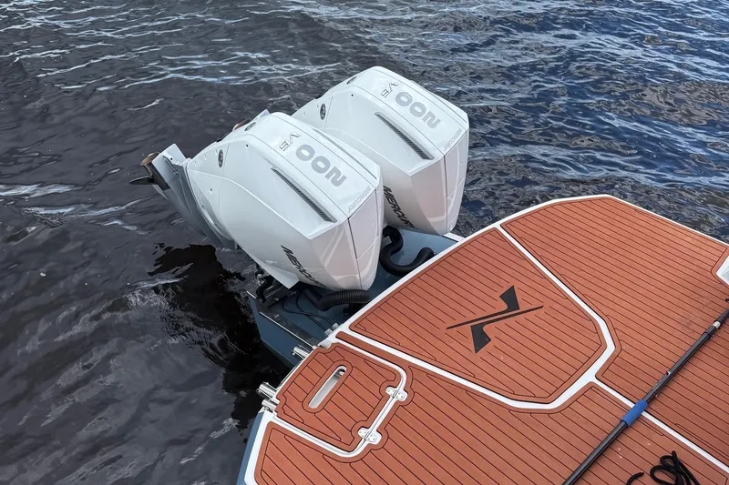 Slide: The Image of 2025 NX Boats NX290 Exclusive with dual outboard motors on water. - 12