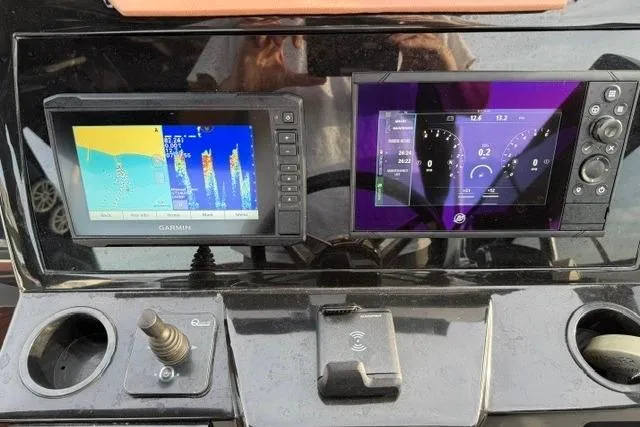 Slide: The Image of Dashboard of 2025 NX Boats NX290 Exclusive with dual navigation screens and controls. - 5