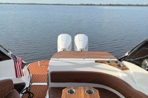 Slide: The Image of 2025 NX Boats NX290 Exclusive on water, featuring dual engines and luxurious deck seating. - 6