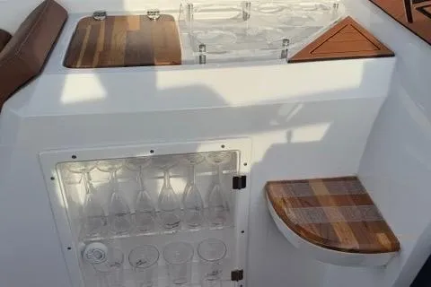 Slide: The Image of 2025 NX Boats NX290 Exclusive interior with wooden accents and glass storage. - 7