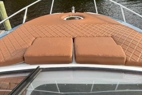 Slide: The Image of 2025 NX Boats NX290 Exclusive with luxurious tan deck cushions on a serene water backdrop. - 9